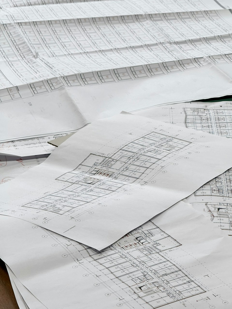 Architectural floor plan drawings laid out on a desk